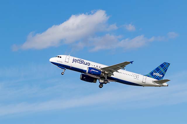 Jetblue aircraft taking off into the blue skies