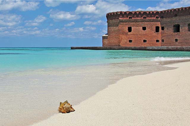 Floriday Keys coastline with turquoise seas and white sandy beaches. An old red castle stretches out into the sea