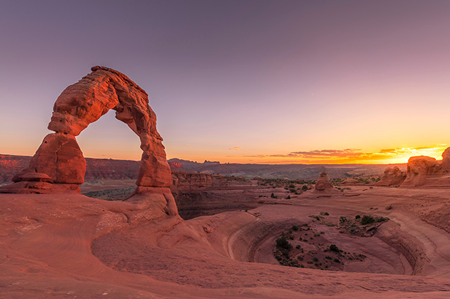 Orange/brown Sandstone rock formation in Arches national park with a setting sun