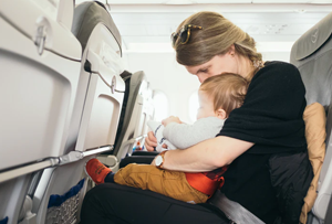 mother with baby on her lap on a plane seat