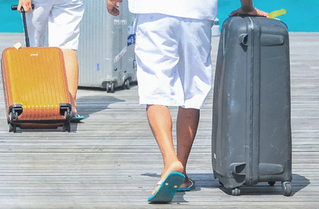 a photo of someone in sandals pulling along a suitcase. 